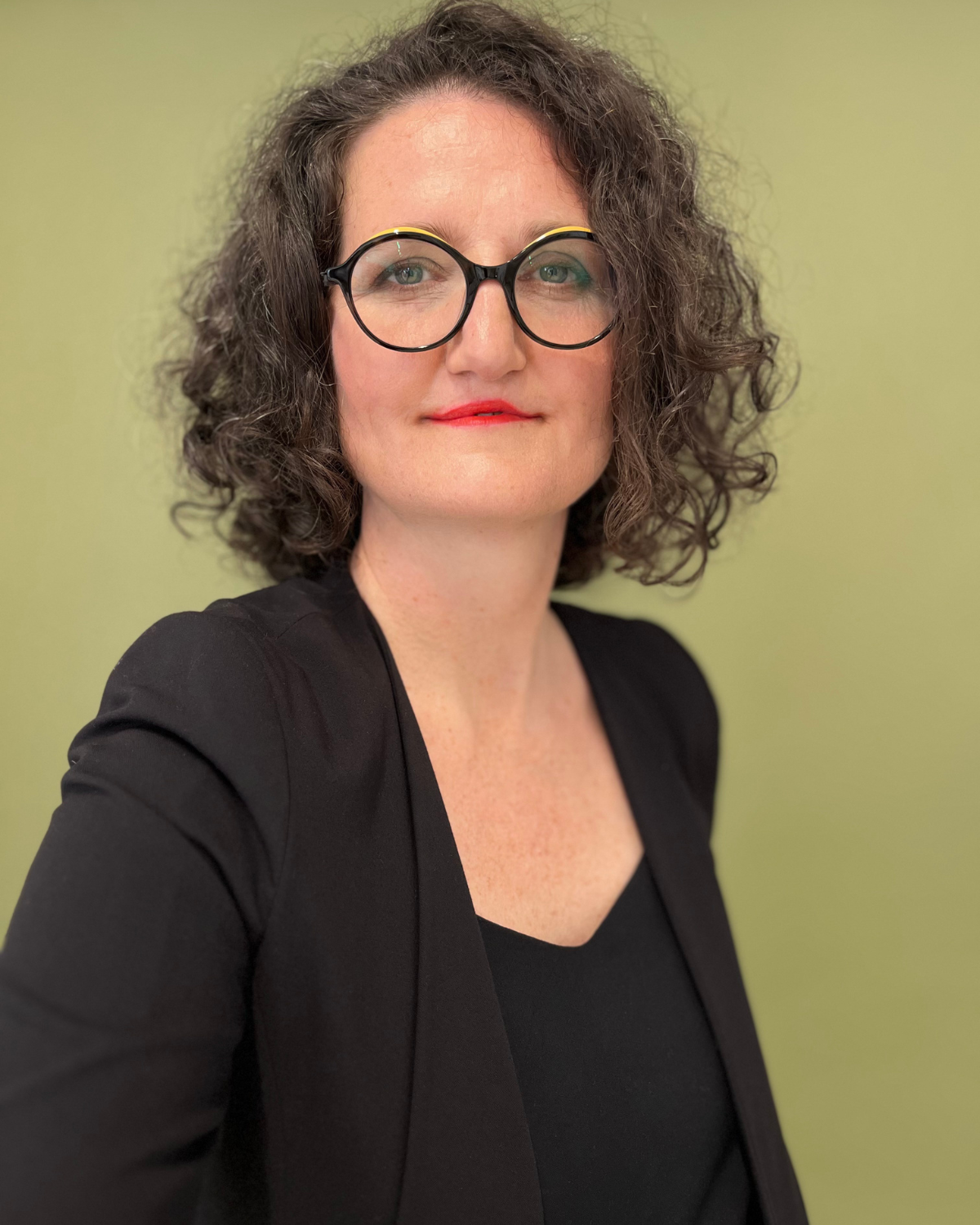 Selfie-Workshop für profesionelle Fotos -Selbstprotrait einer Frau mit Brille und scharzem Blaser. Personal Branding Fotografie